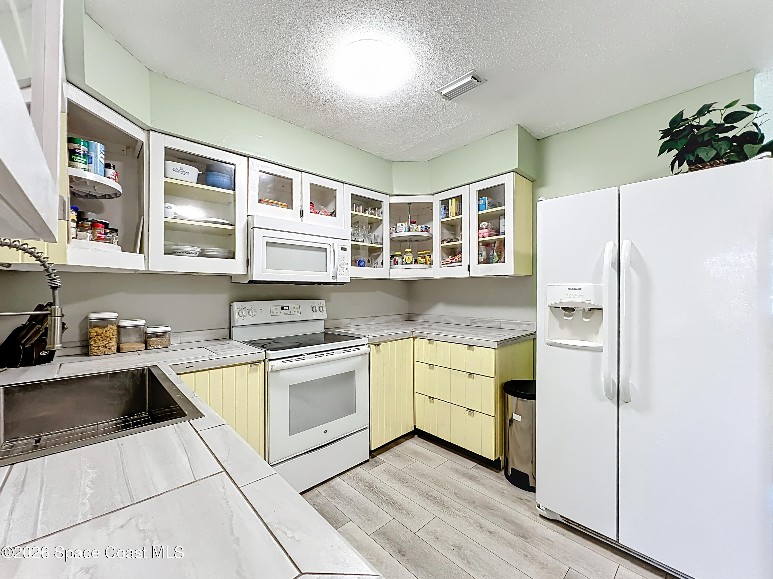 854 Angle Street Northeast Palm Bay, FL 32905 - Photo 12 of 23 a kitchen with a white stove top oven and refrigerator