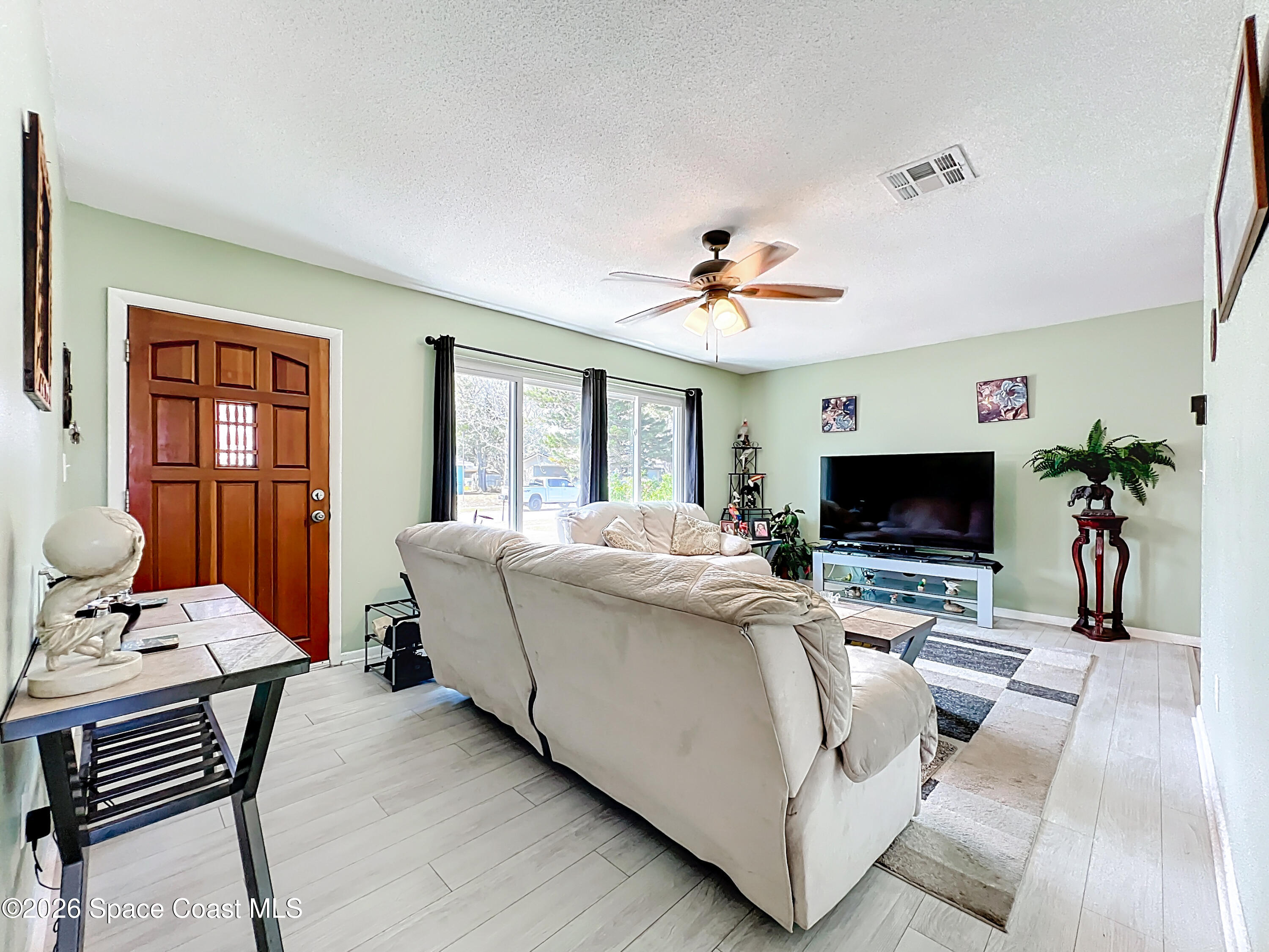 854 Angle Street Northeast Palm Bay, FL 32905 - Photo 7 of 23 a living room with furniture and a flat screen tv