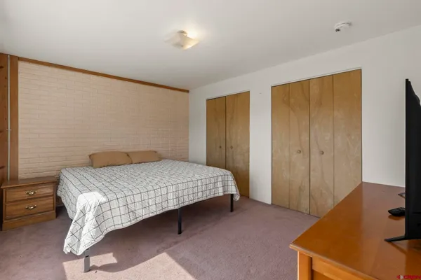 a bedroom with a bed and a dresser in it