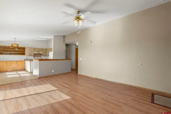a view of a kitchen with wooden floor and an empty space