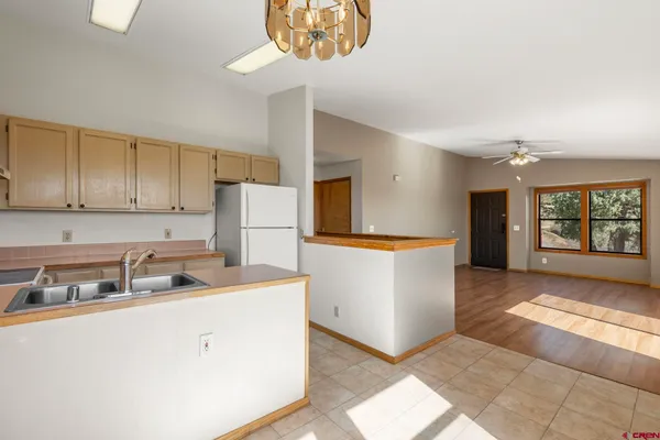 a kitchen with kitchen island white cabinets and refrigerator