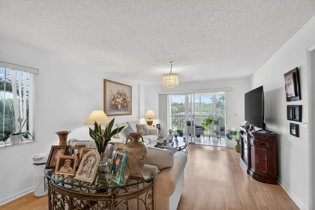 a living room with furniture a flat screen tv and a large window