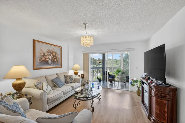 a living room with furniture a chandelier and a flat screen tv