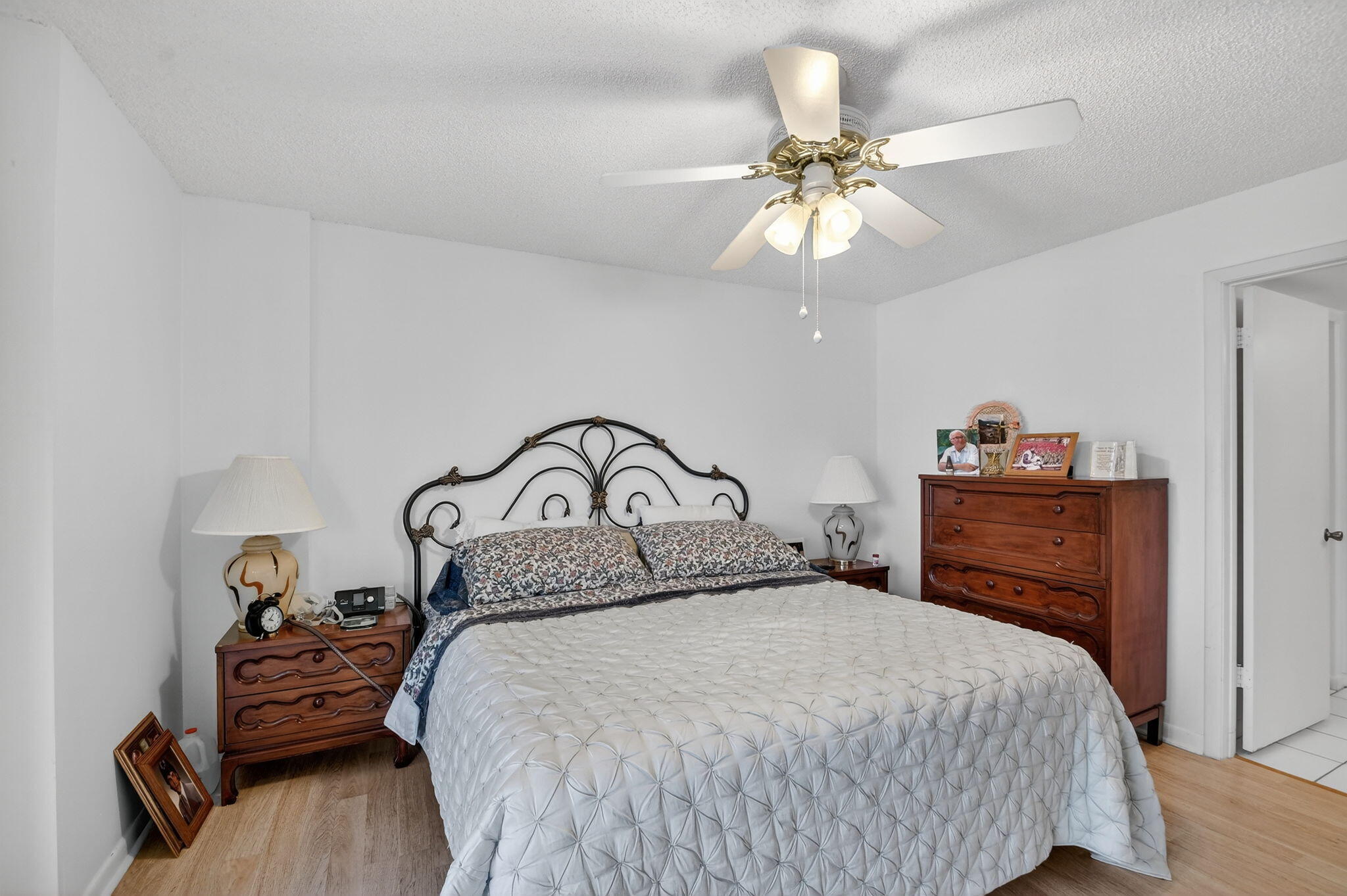 3146 Via Poinciana, Unit 301 Lake Worth, FL 33467 - Photo 16 of 23 a bedroom with a bed and a chandelier