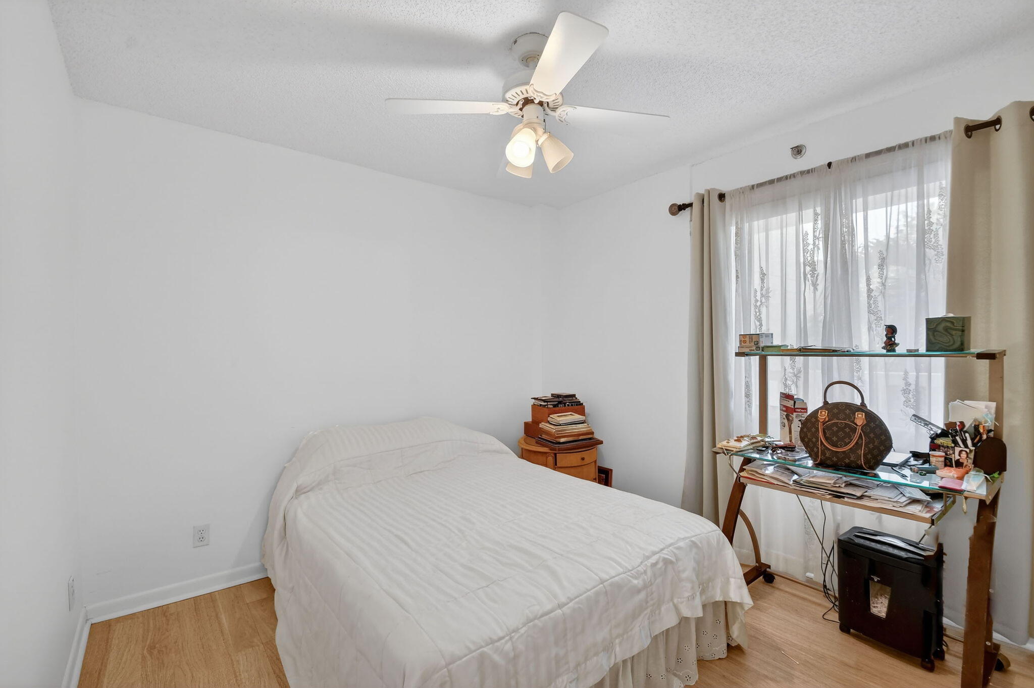 3146 Via Poinciana, Unit 301 Lake Worth, FL 33467 - Photo 18 of 23 a bedroom with a bed and a chandelier