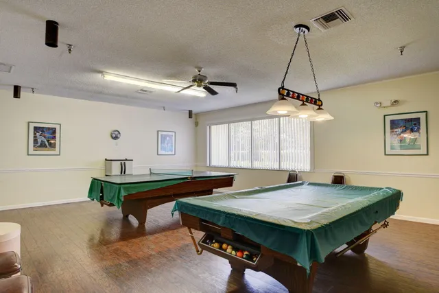 a room with pool table and windows