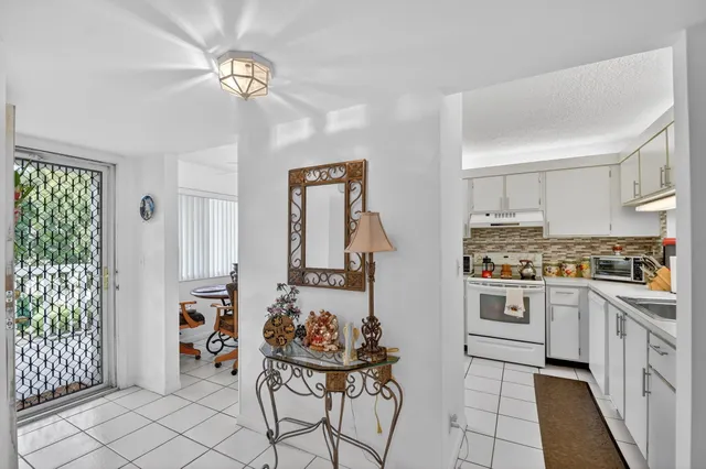 a kitchen with stainless steel appliances a stove a chimney a sink and cabinets