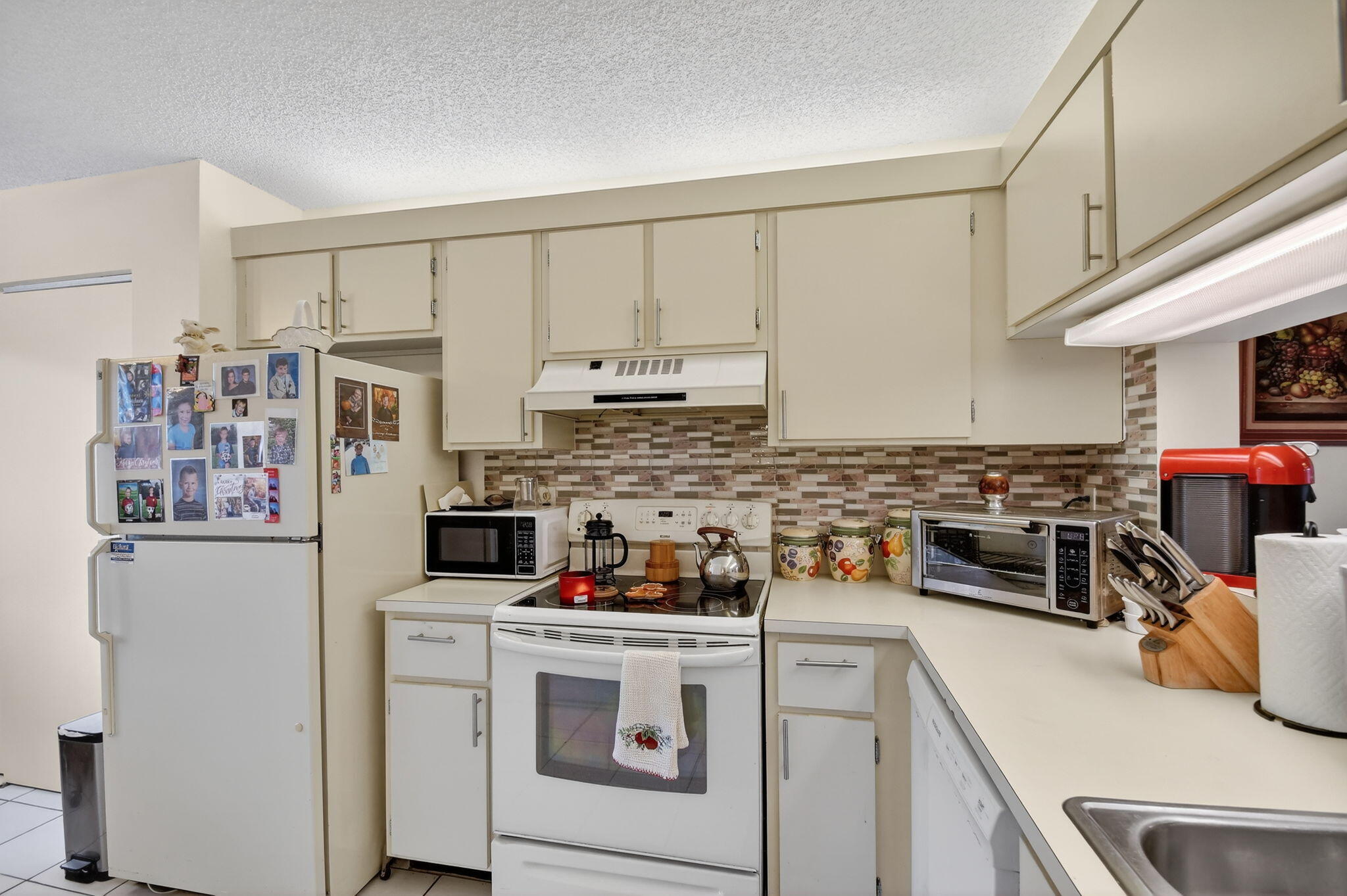 3146 Via Poinciana, Unit 301 Lake Worth, FL 33467 - Photo 5 of 23 a kitchen with stainless steel appliances a white cabinets and a sink