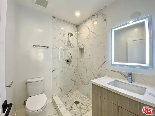 a bathroom with a sink toilet vanity and shower