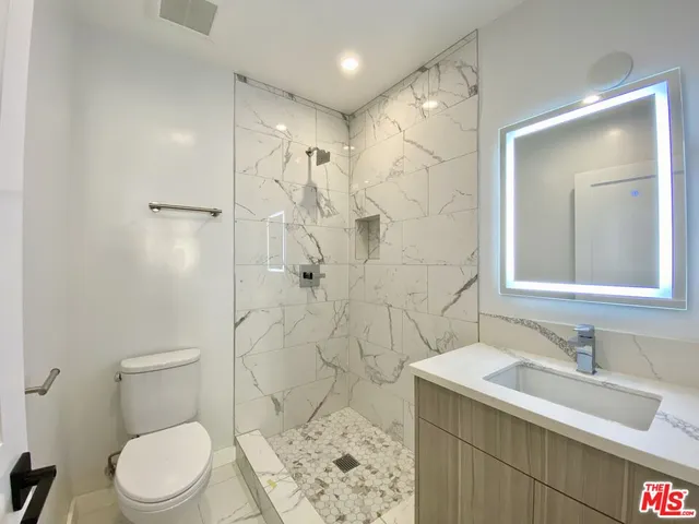 a bathroom with a sink toilet vanity and shower