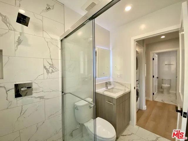 a bathroom with a granite countertop sink a toilet and shower