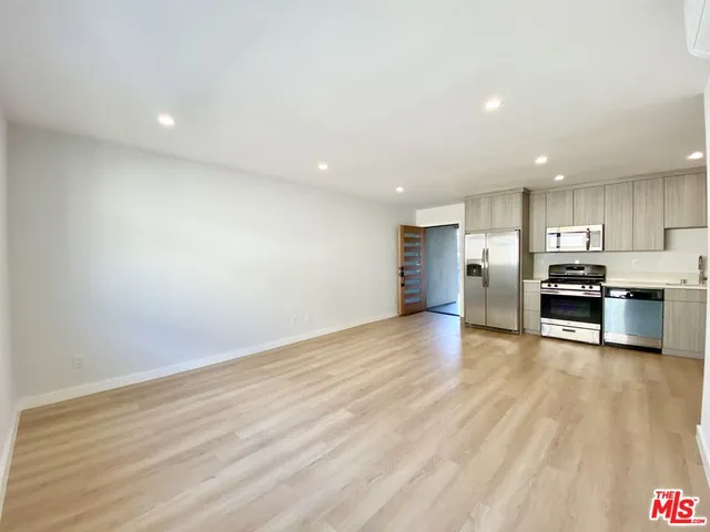 a kitchen with stainless steel appliances a refrigerator and a stove top oven