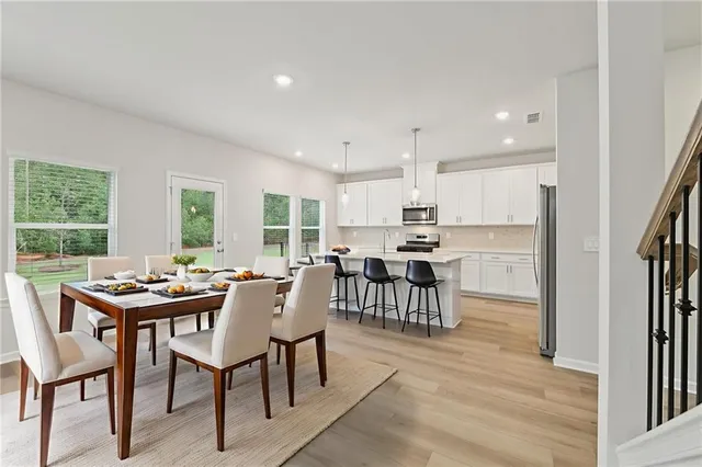 a large white kitchen with a large window a sink and stainless steel appliances