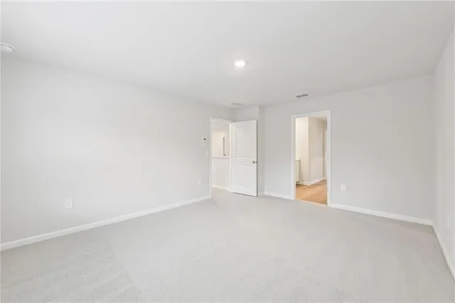 a spacious bathroom with double vanity a mirror and a shower
