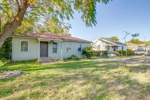 a view of a house with backyard and sitting area