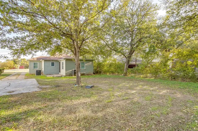 a backyard of a house with table and chairs