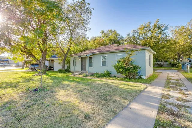a view of a house with backyard and trees