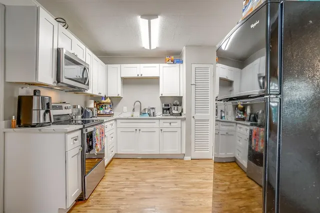 a kitchen with stainless steel appliances granite countertop a refrigerator and a sink