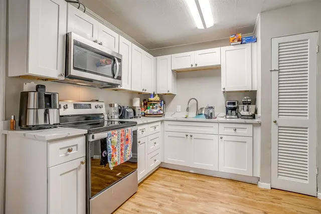 a kitchen with stainless steel appliances granite countertop a sink and cabinets