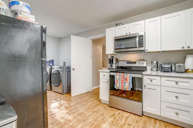 a kitchen with white cabinets and appliances