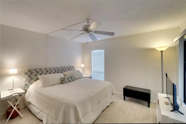 a bedroom with a bed and a ceiling fan