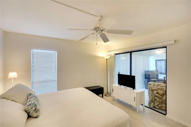 a bedroom with a bed flat screen tv and a chandelier