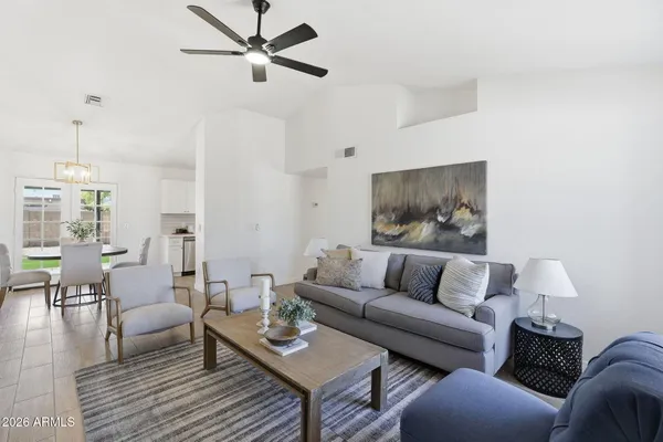 a living room with furniture and a wooden floor