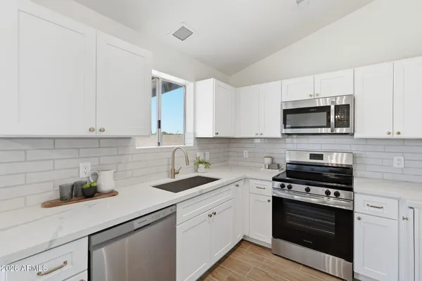 a kitchen with white cabinets and stainless steel appliances