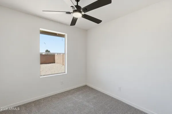 an empty room with a window and a fan