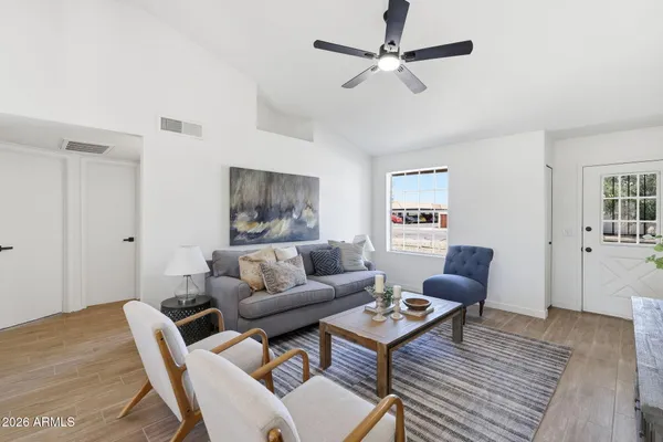 a living room with furniture and a wooden floor