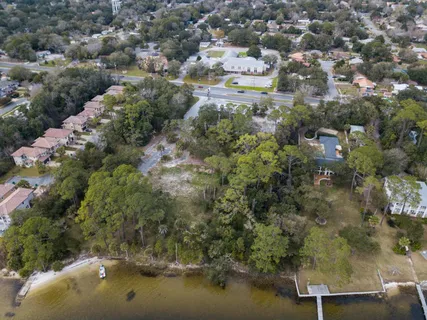 an aerial view of residential houses with outdoor space and trees