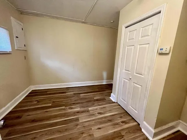 a view of a room with wooden floor and white walls