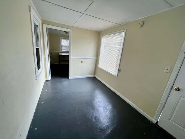 a room with table chairs and windows