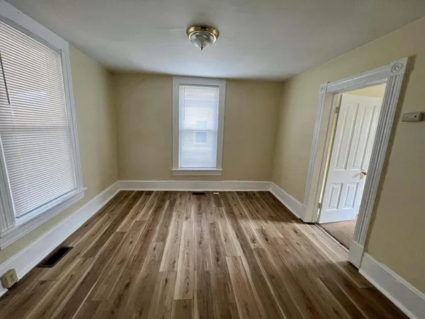 a view of a room with wooden floor and window