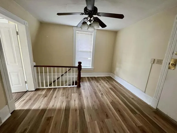 a view of hallway with wooden floor and chandelier