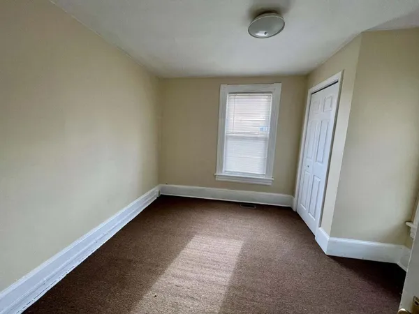 an empty room with a chair and a window