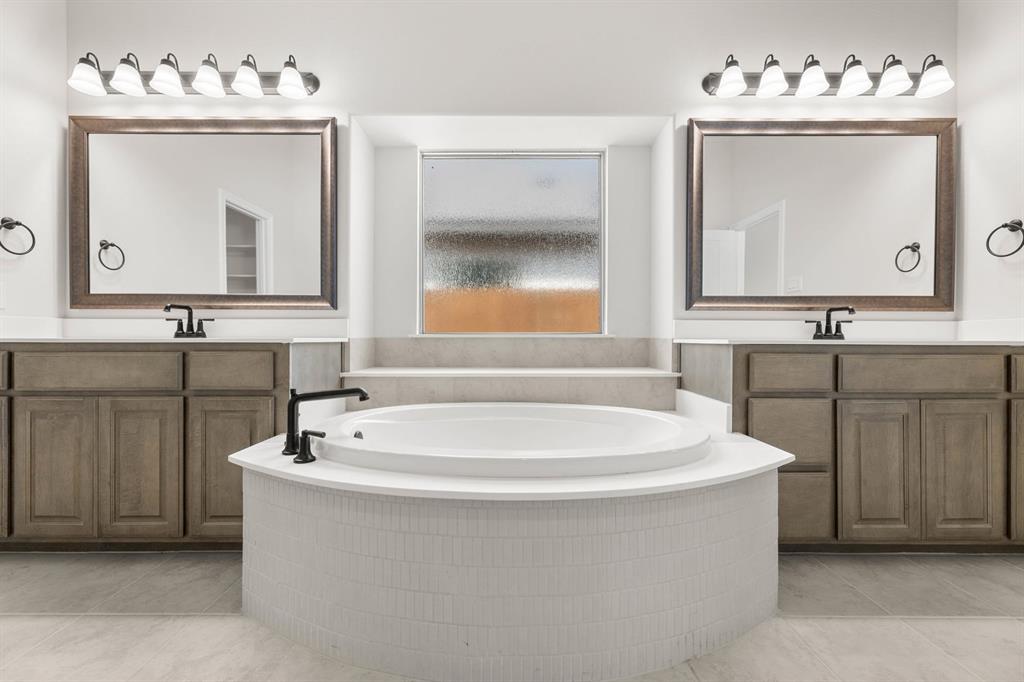 713 Seahawk Street Joshua, TX 76058 - Photo 15 of 31 a bathroom with a sink mirror and a bathtub