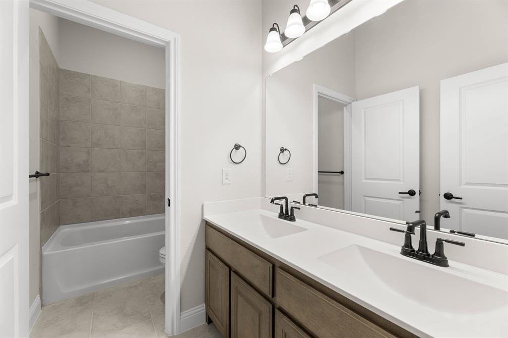 713 Seahawk Street Joshua, TX 76058 - Photo 19 of 31 a bathroom with a sink a mirror and a bathtub