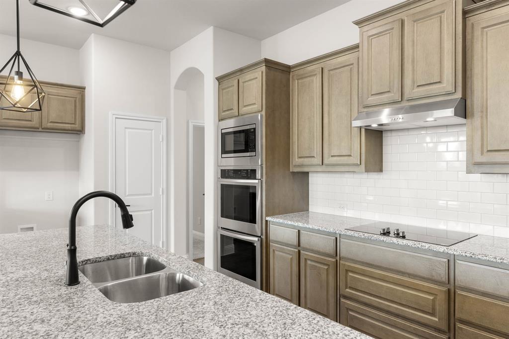 713 Seahawk Street Joshua, TX 76058 - Photo 3 of 31 a kitchen with stainless steel appliances granite countertop a sink a stove and cabinets