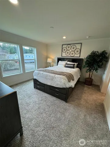 a spacious bedroom with a bed and a large window