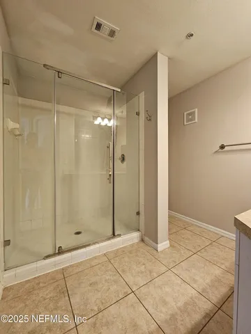 a view of an empty room with wooden floor and a ceiling fan
