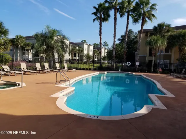 a view of a swimming pool with palm trees