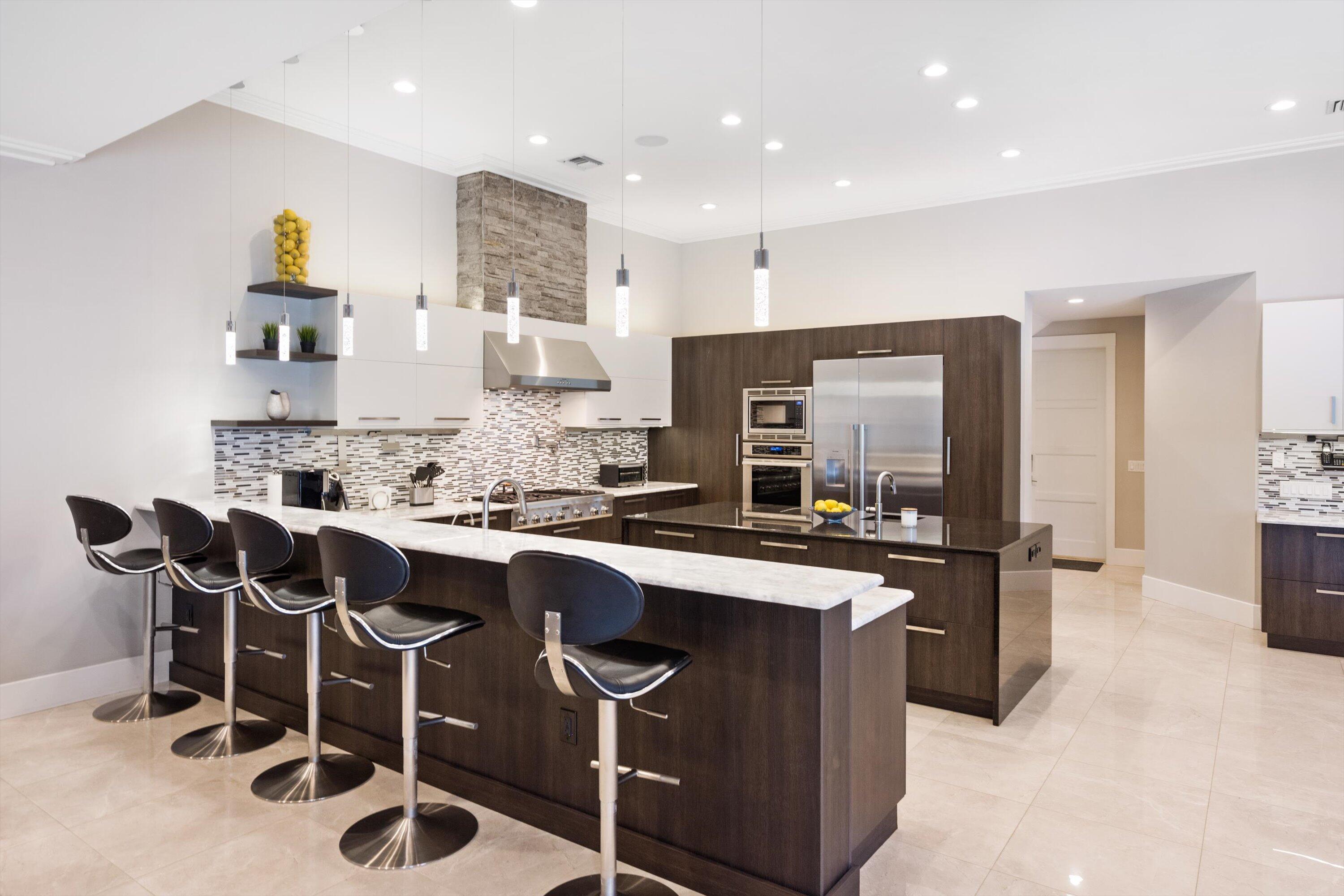 15880 Barnstormer Court Wellington, FL 33414 - Photo 14 of 48 a kitchen with stainless steel appliances granite countertop a sink and a refrigerator