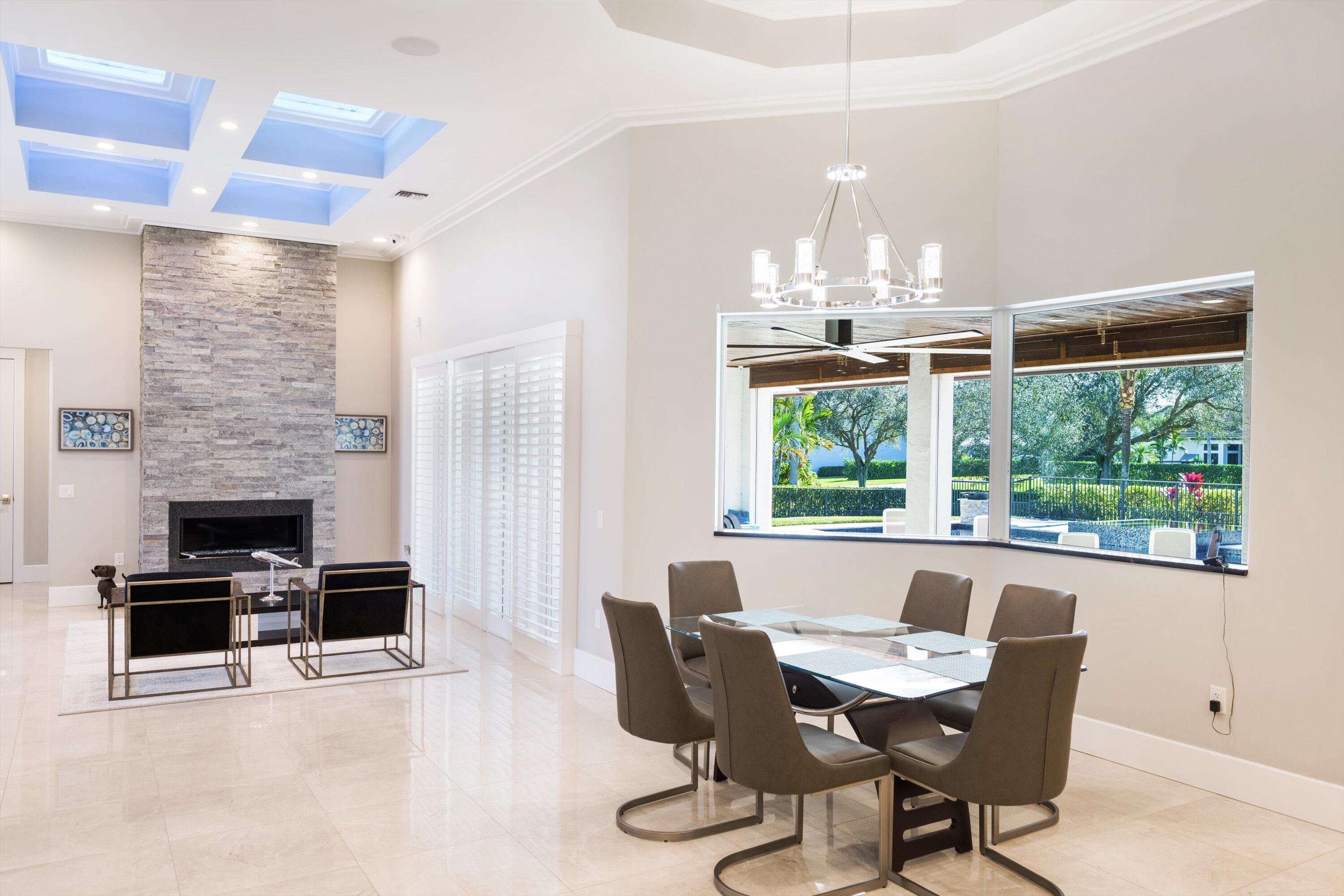 15880 Barnstormer Court Wellington, FL 33414 - Photo 15 of 48 a dining room with furniture a fireplace and large windows