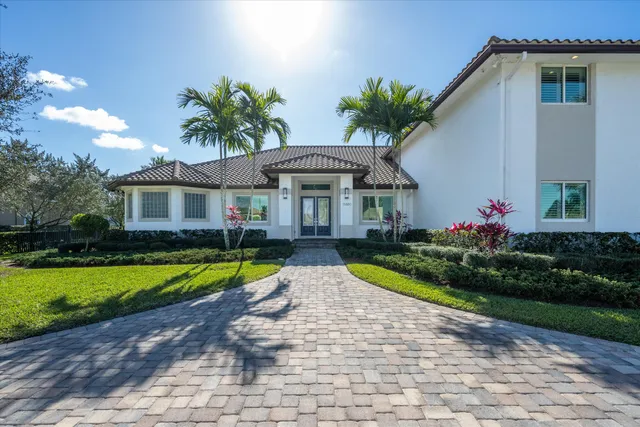 a front view of house with small garden and trees