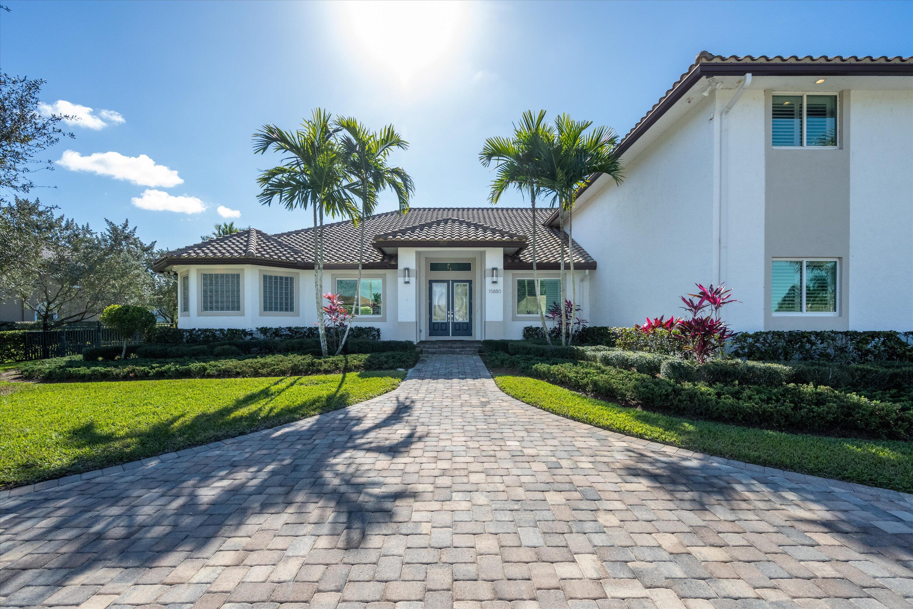 15880 Barnstormer Court Wellington, FL 33414 - Photo 2 of 48 a front view of house with small garden and trees
