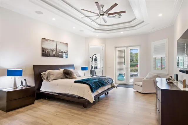 a spacious bedroom with a bed a couch and large window