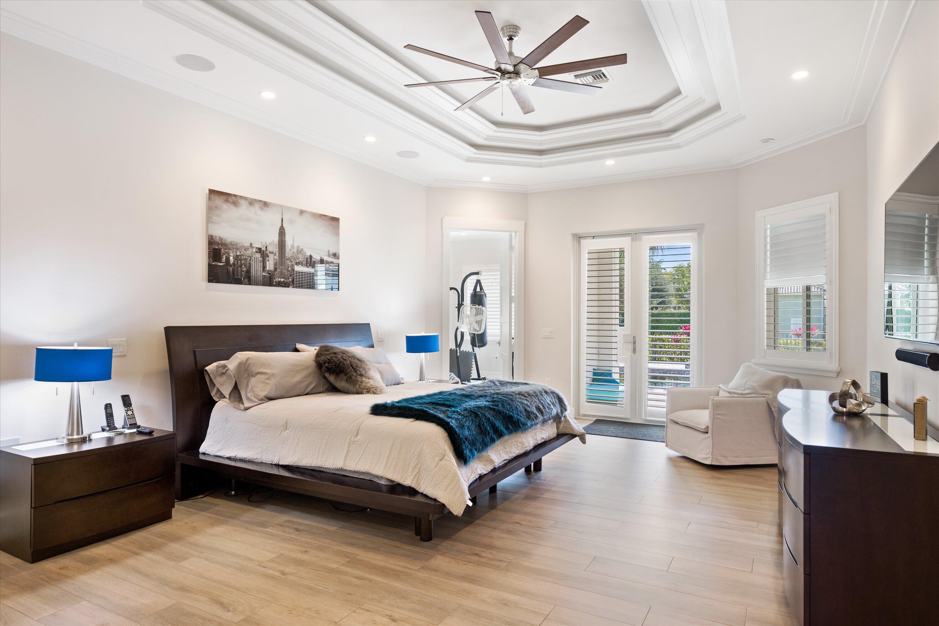 15880 Barnstormer Court Wellington, FL 33414 - Photo 23 of 48 a spacious bedroom with a bed a couch and large window