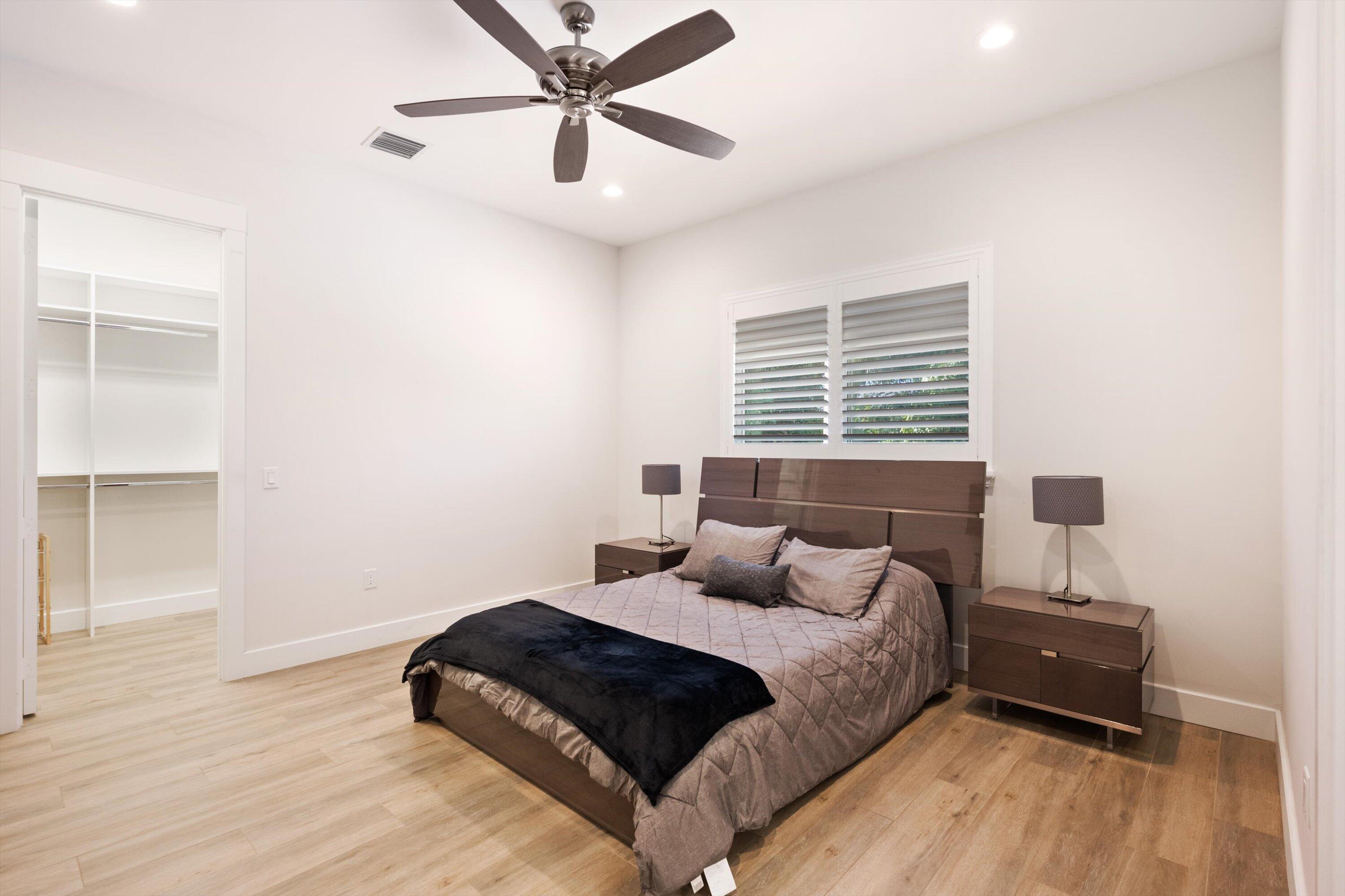 15880 Barnstormer Court Wellington, FL 33414 - Photo 30 of 48 a bedroom with a bed and wooden floor