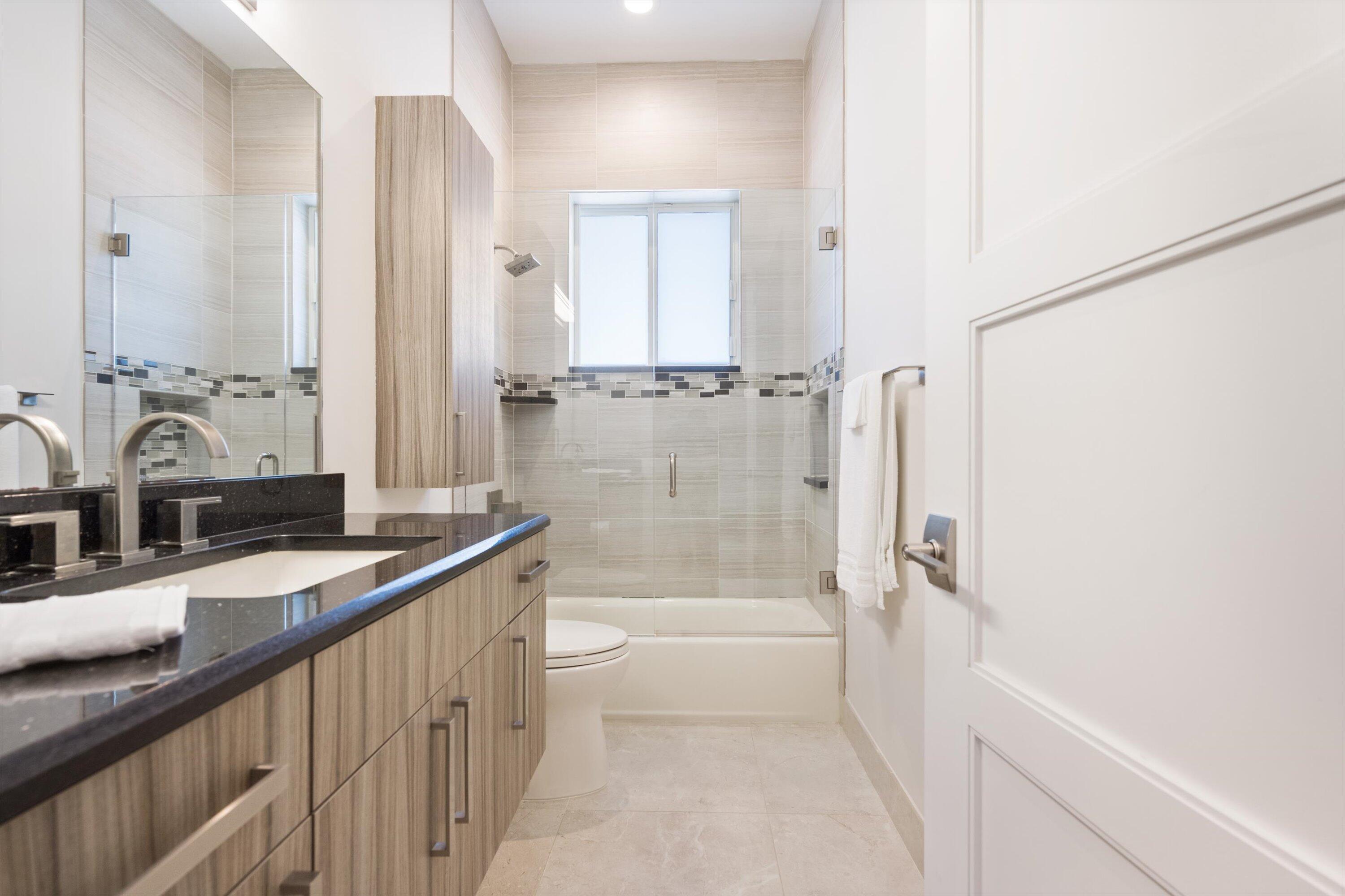 15880 Barnstormer Court Wellington, FL 33414 - Photo 34 of 48 a bathroom with a granite countertop sink a mirror and a bathtub